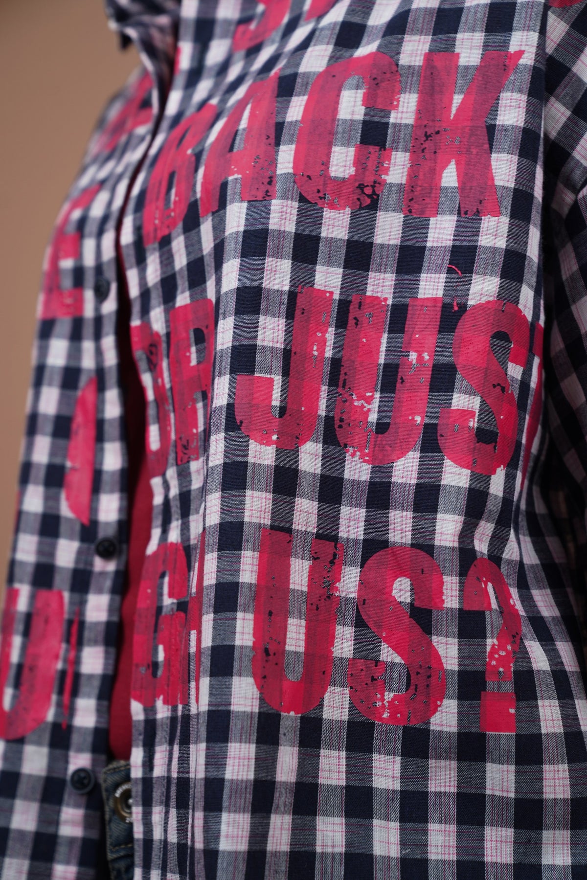 Close-up of a navy and white gingham plaid unisex streetwear shirt with large distressed red text reading 'BACK OR JUST US?' across the front.